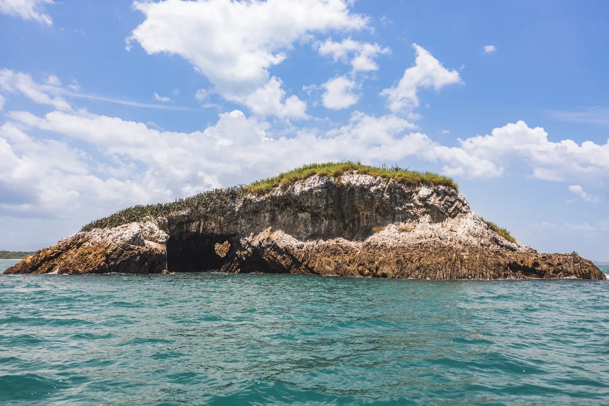 Isla Farallón rising from the Pacific ocean with crystal clear surrounding waters
